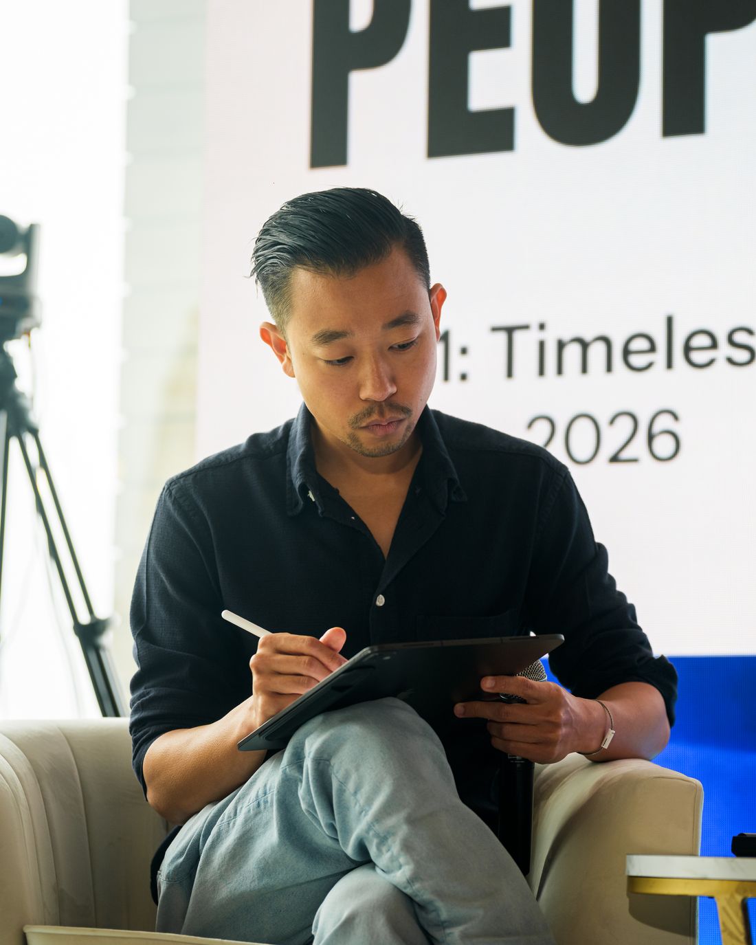 Joseph Quan taking notes on stage at a CPOHQ event