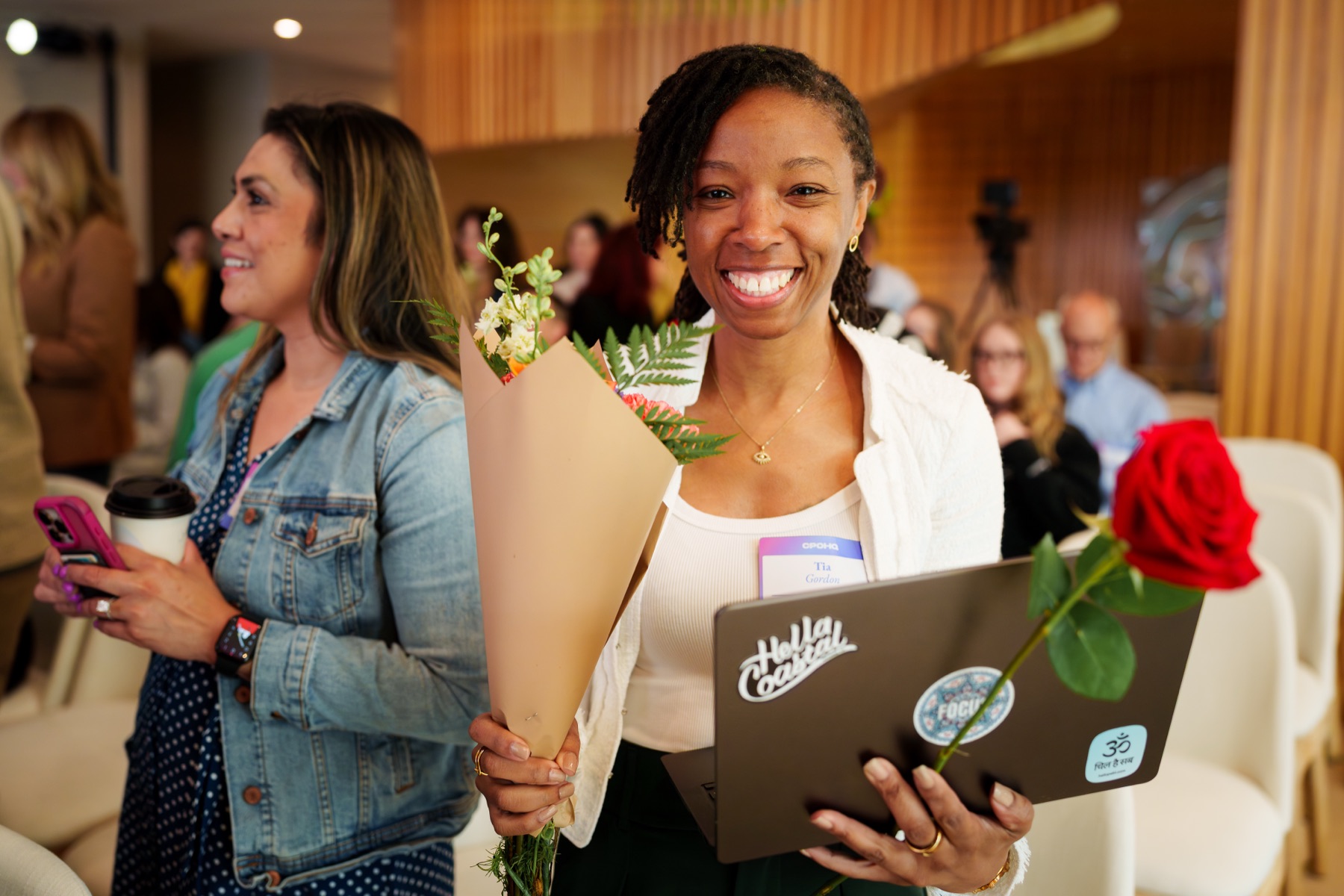 A teammate laughing with her laptop and flowers